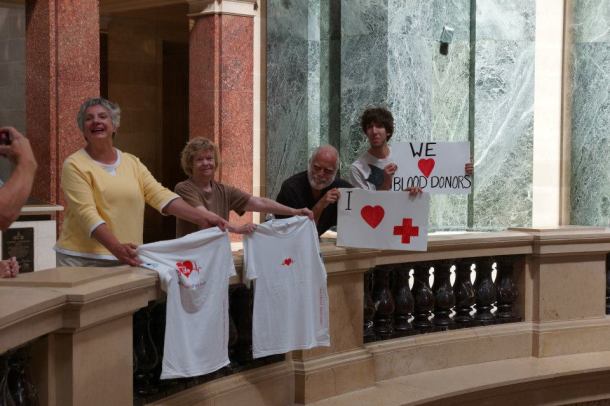 Three of these citizens received citations for holding up signs and t-shirts during a Red Cross blood drive in September. Signs and t-shirts are extremely protected First Amendment speech and all have requested jury trials. Photo credit:  Leslie Amsterdam