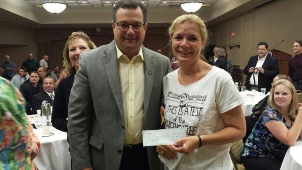 National Postal Press Association President Tony Carobine presents a check to Katy Reeder of the First Amendment Protection Fund.  Photo by Chaous