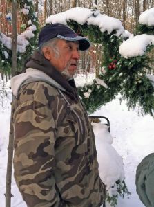 Mel Gaspar in front of dream catcher wreaths at the HELP camp on Thanksgiving. Photo courtesy of Ros Nelson.