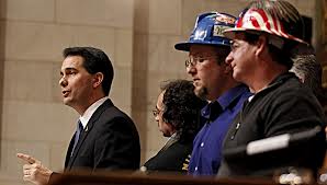 Larry Youngs, Iron County Board Supervisor and Mining Impact Committee member can be seen next to Walker in the decorated hard hat with other locals in the picture on the right.