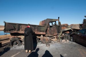 A member of the clergy prays in front of a burnt out truck of the Dakota Access pipeline on the Standing Rock Indian Reservation. Photo: Stephanie Keith/Reuters
